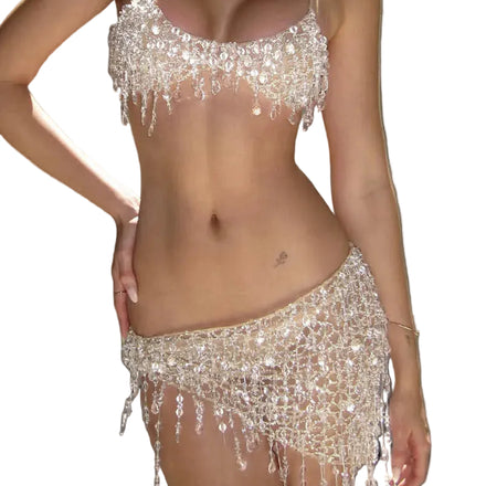 Woman wearing a sparkling silver bikini with a matching skirt against a neutral background